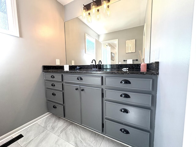 bathroom featuring marble finish floor, baseboards, a chandelier, and vanity