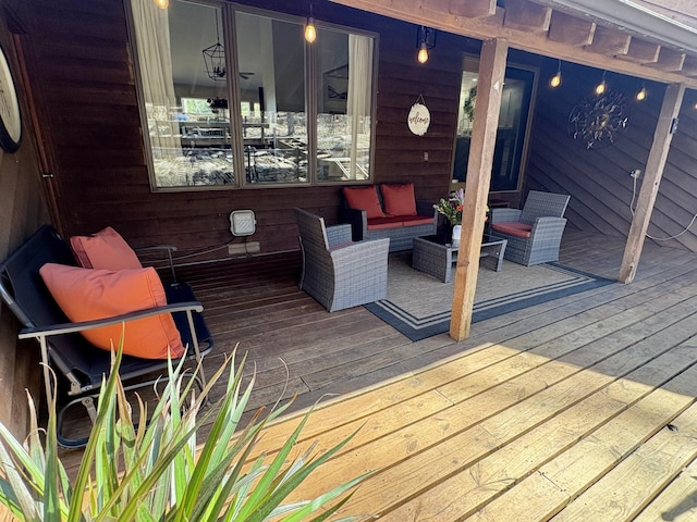 wooden terrace with an outdoor living space