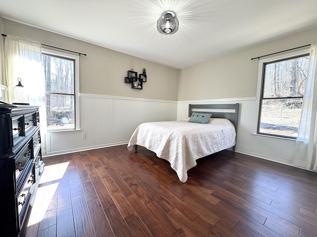 bedroom featuring hardwood / wood-style floors and wainscoting