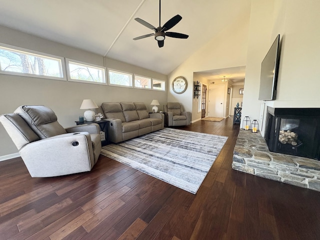 living room with dark wood finished floors, a ceiling fan, a stone fireplace, high vaulted ceiling, and baseboards