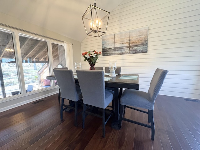 dining space with visible vents, an inviting chandelier, dark wood-type flooring, vaulted ceiling, and baseboards