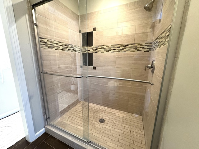 bathroom featuring tile patterned flooring and a shower stall