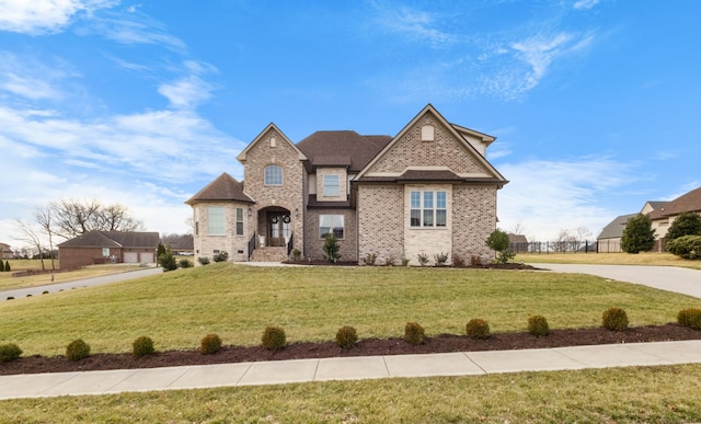 french country style house with brick siding and a front lawn