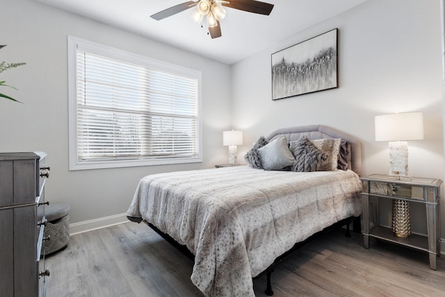 bedroom featuring ceiling fan, wood finished floors, and baseboards