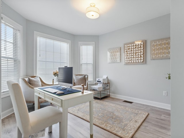 office featuring visible vents, baseboards, and wood finished floors