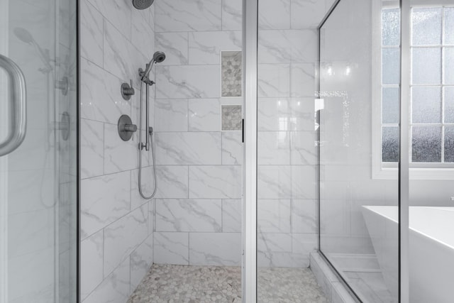 bathroom featuring a stall shower and a freestanding tub