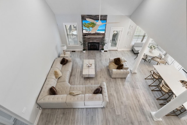 living area featuring a fireplace, baseboards, and wood finished floors