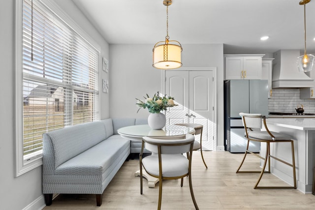 dining area featuring light wood-style flooring, breakfast area, baseboards, and recessed lighting