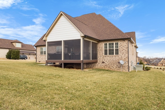 rear view of house featuring a yard, brick siding, roof with shingles, and a sunroom