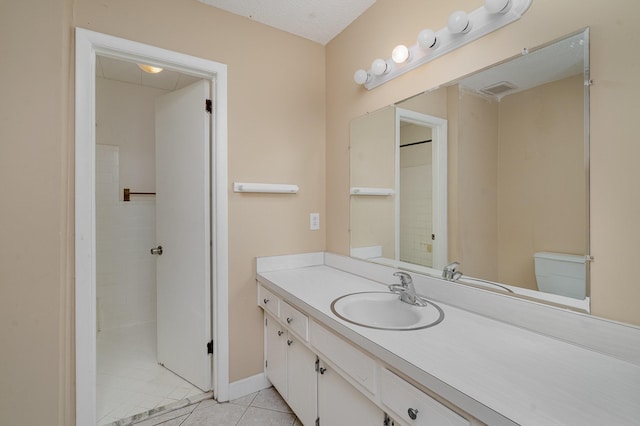 bathroom featuring toilet, tile patterned flooring, vanity, and baseboards