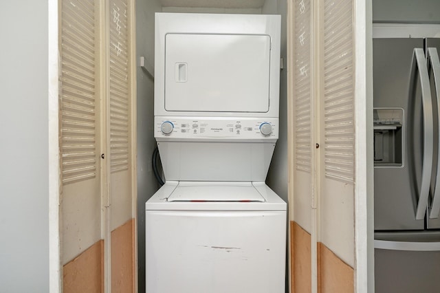 clothes washing area featuring laundry area and stacked washing maching and dryer