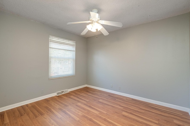 spare room with ceiling fan, light wood-style flooring, visible vents, and baseboards