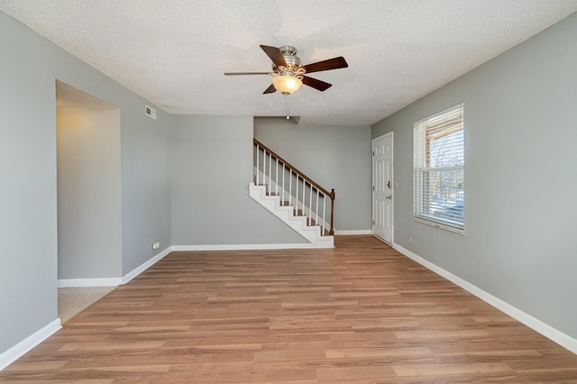 entryway with stairway, light wood-type flooring, and baseboards