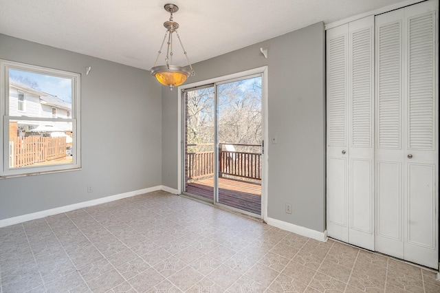 unfurnished dining area featuring plenty of natural light and baseboards