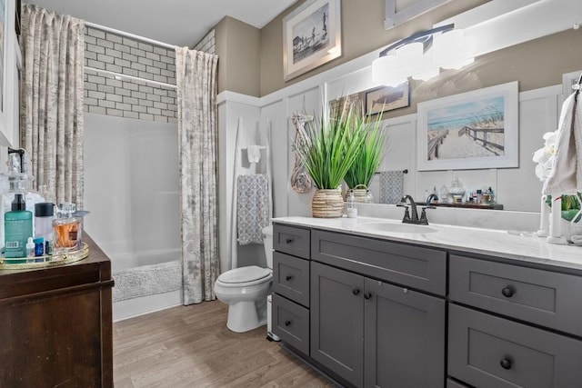 bathroom with vanity, wood finished floors, toilet, and a shower with curtain