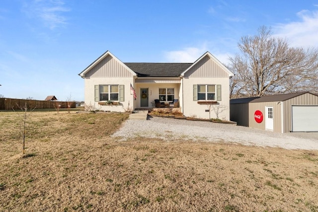 view of front of house with a garage, an outbuilding, fence, and a front yard