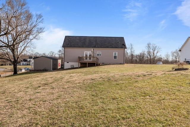 rear view of property with crawl space, a deck, an outdoor structure, and a yard