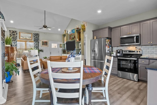 kitchen featuring appliances with stainless steel finishes, gray cabinets, light wood-style flooring, and tasteful backsplash