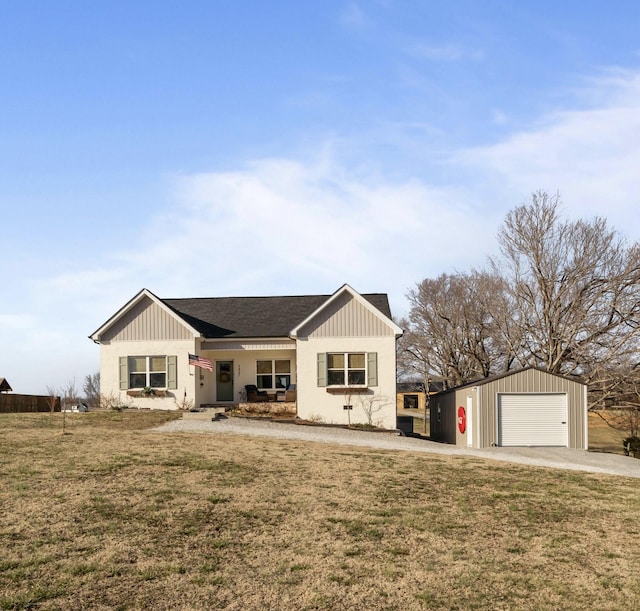 view of front of house with a garage, a front lawn, and an outdoor structure