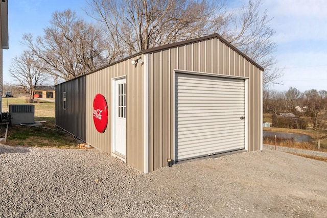 detached garage featuring central AC and gravel driveway