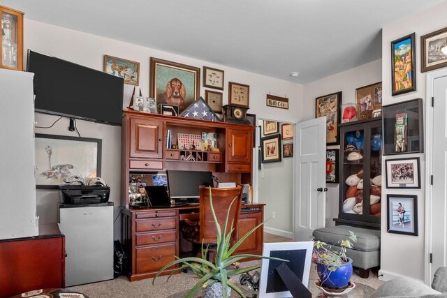 carpeted office featuring baseboards