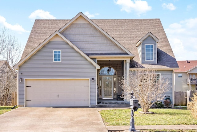 view of front facade with driveway, a garage, roof with shingles, fence, and a front yard