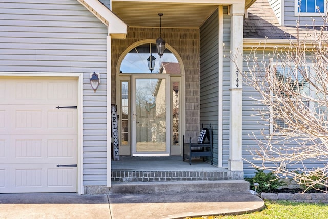 property entrance featuring a garage and roof with shingles