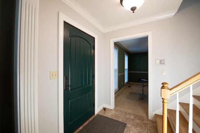 entryway with light tile patterned floors, stairway, ornamental molding, light carpet, and baseboards