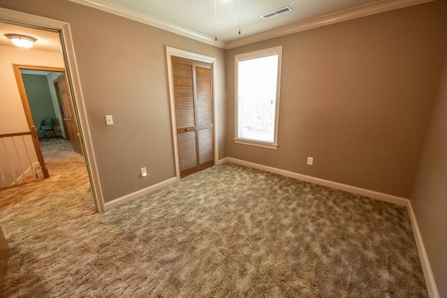 unfurnished bedroom with carpet, visible vents, and crown molding