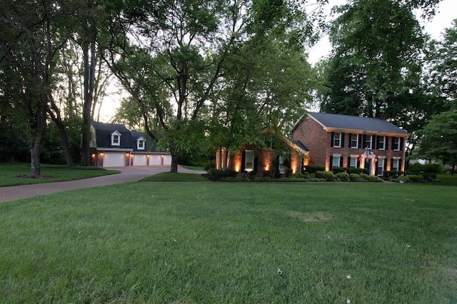 view of front facade with a garage, a front yard, and brick siding