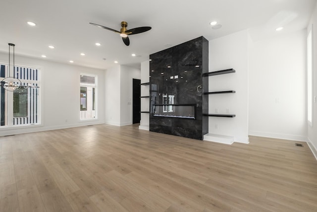 unfurnished living room featuring light wood-style floors, a premium fireplace, and recessed lighting