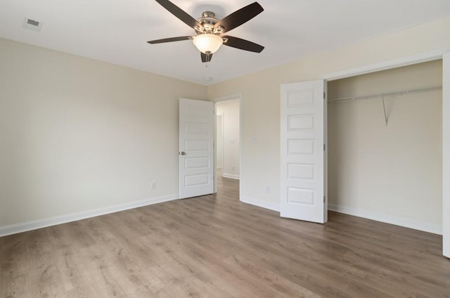 unfurnished bedroom featuring a closet, ceiling fan, baseboards, and wood finished floors