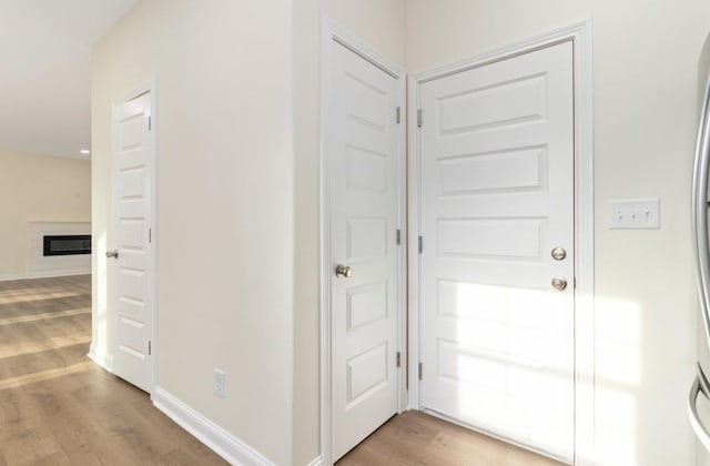 interior space featuring light wood-type flooring and baseboards