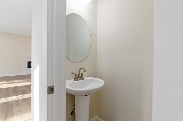 bathroom featuring a sink, wood finished floors, and baseboards