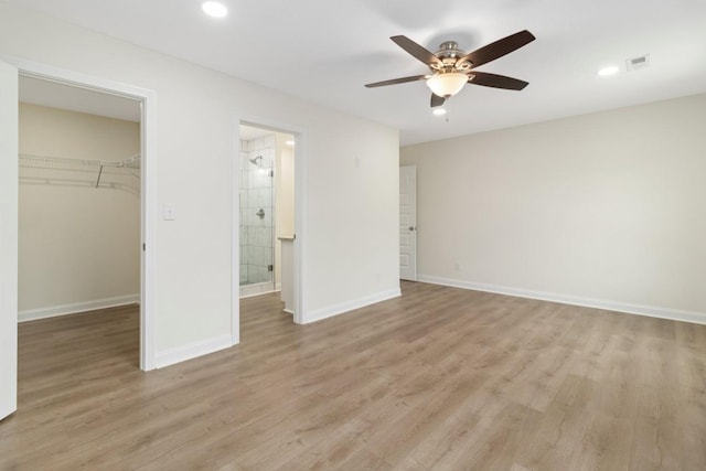 unfurnished bedroom featuring recessed lighting, a closet, a spacious closet, light wood-type flooring, and baseboards