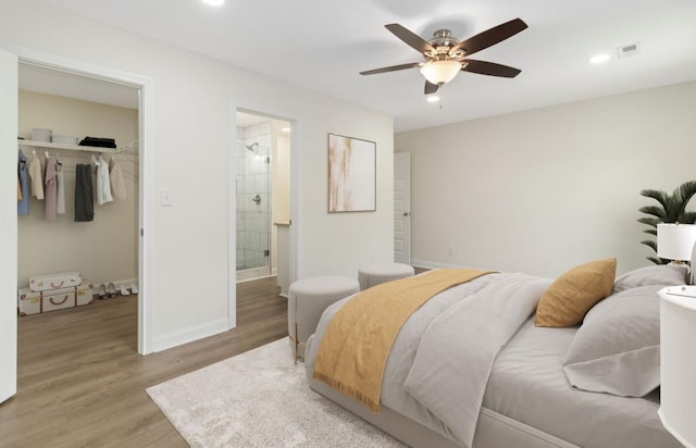 bedroom with baseboards, visible vents, a spacious closet, light wood-type flooring, and a closet