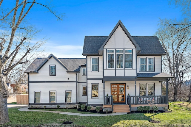 view of front of property with a porch, a front yard, french doors, and roof with shingles