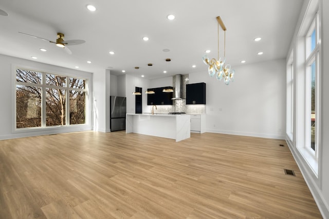 unfurnished living room featuring a wealth of natural light, light wood-type flooring, visible vents, and recessed lighting