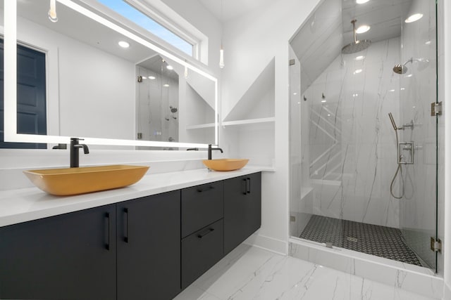 bathroom featuring double vanity, marble finish floor, a marble finish shower, and a sink