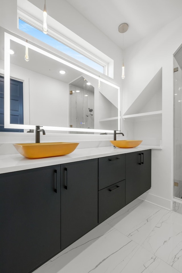 bathroom with double vanity, a marble finish shower, and a sink