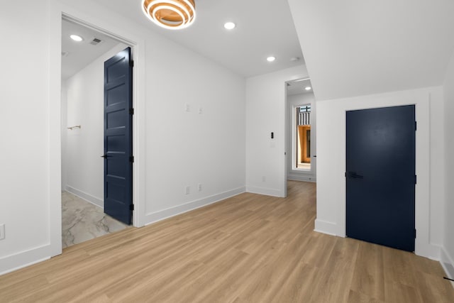 empty room featuring baseboards, light wood-style flooring, and recessed lighting