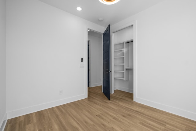 unfurnished bedroom with light wood-style floors, baseboards, a closet, and recessed lighting