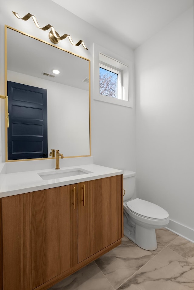 half bath featuring toilet, marble finish floor, visible vents, and vanity