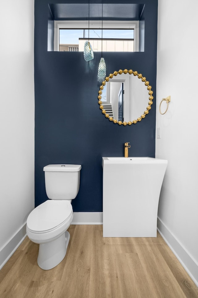 bathroom featuring baseboards, toilet, and wood finished floors