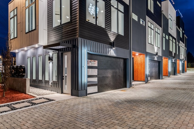 exterior space featuring decorative driveway and an attached garage