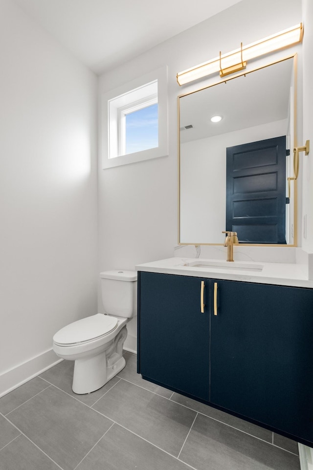 half bath with visible vents, baseboards, toilet, tile patterned floors, and vanity