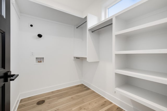 walk in closet with light wood-style flooring