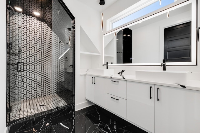 full bath with marble finish floor, a tile shower, a sink, and double vanity