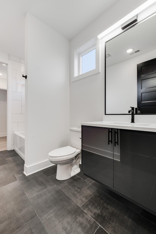 full bathroom featuring toilet, vanity, visible vents, baseboards, and  shower combination