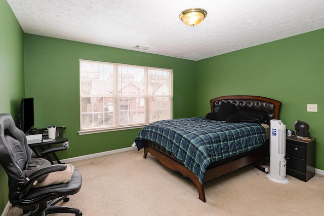 carpeted bedroom with visible vents, a textured ceiling, and baseboards